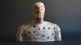 Observer, a single white glazed textured and punctured figure from the Enlightenment installation. Earthenware terra-cotta glazed made by contemporary ceramic artist Simon Fell