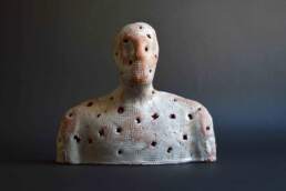 Observer, a single white glazed textured and punctured figure from the Enlightenment installation. Earthenware terra-cotta glazed made by contemporary ceramic artist Simon Fell