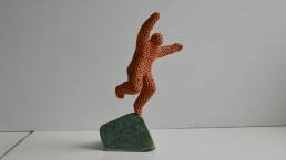 Leap of faith - patterned terracotta figure on a glazed base