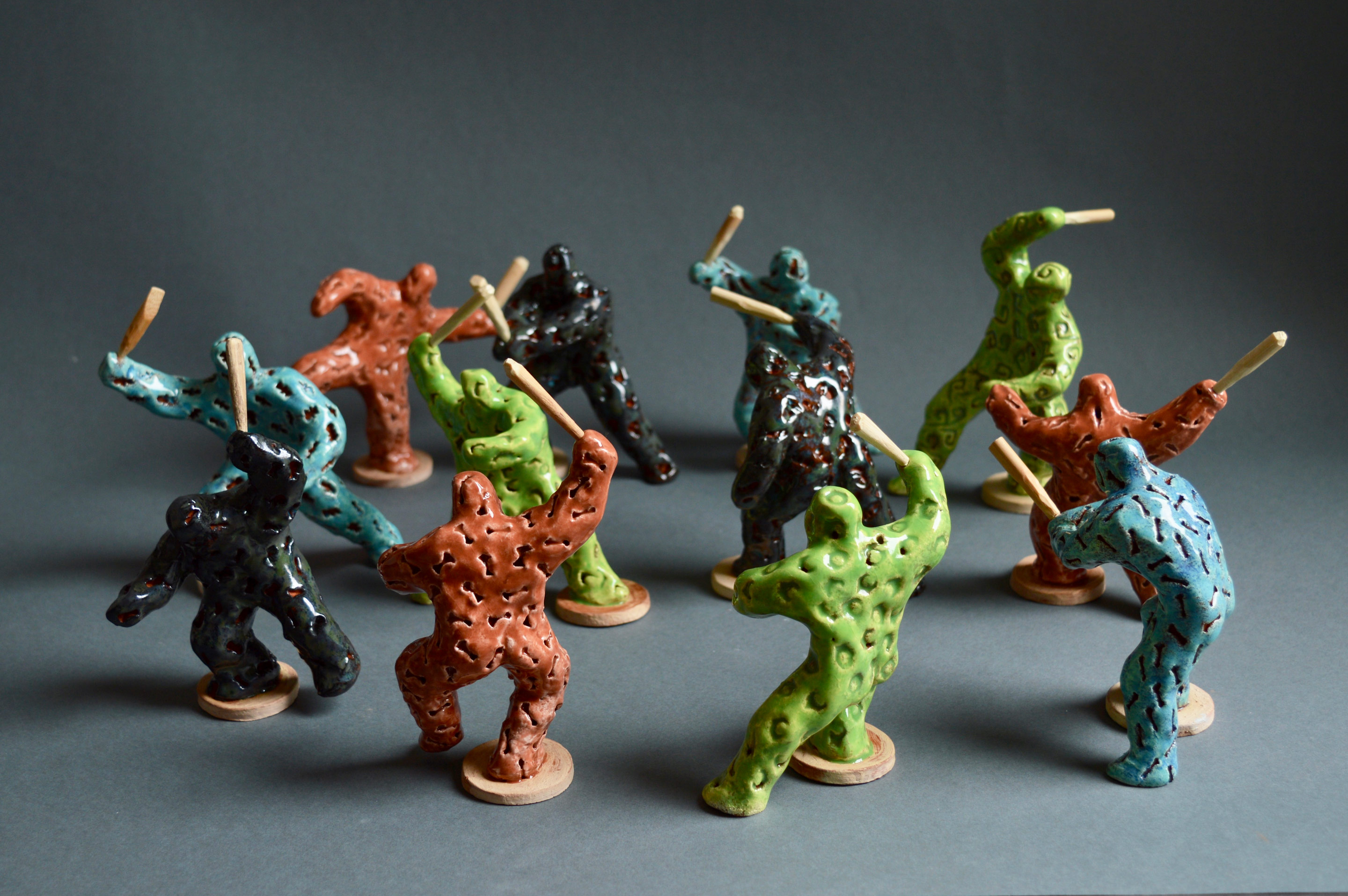 Riot of colour - twelve small coloured figures with clubs, figures about 10cm tall
