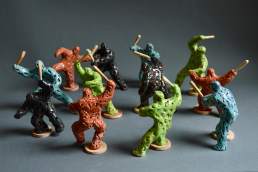 Riot of Colour - twelve small glazed coloured figures with clubs, figures about 10cm tall