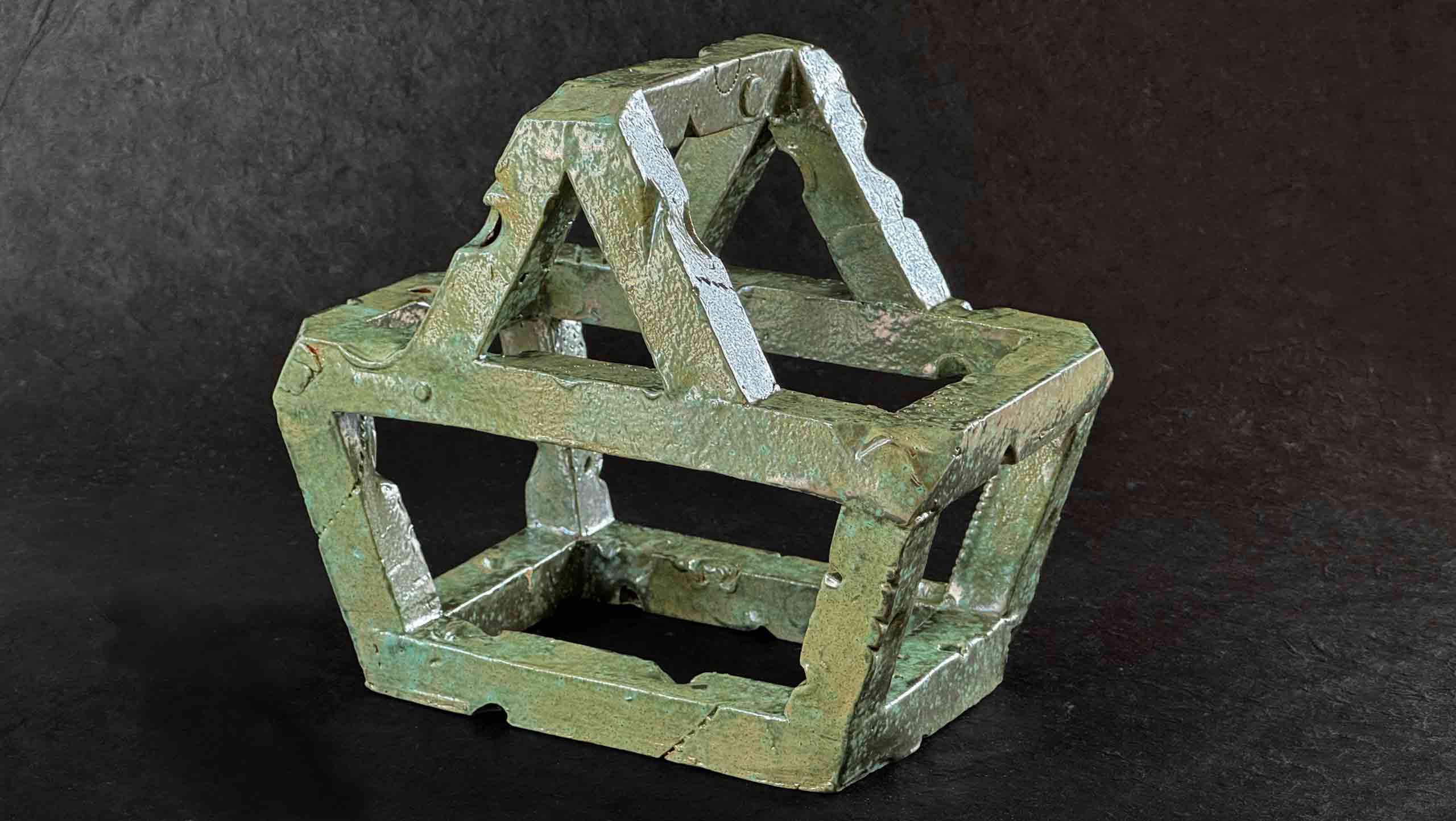 Unexpected Item - A ceramic object in the shape of a supermarket shopping basket made with extruded square section tubes of earthenware clay, fired and glazed with a reflective copper glaze
