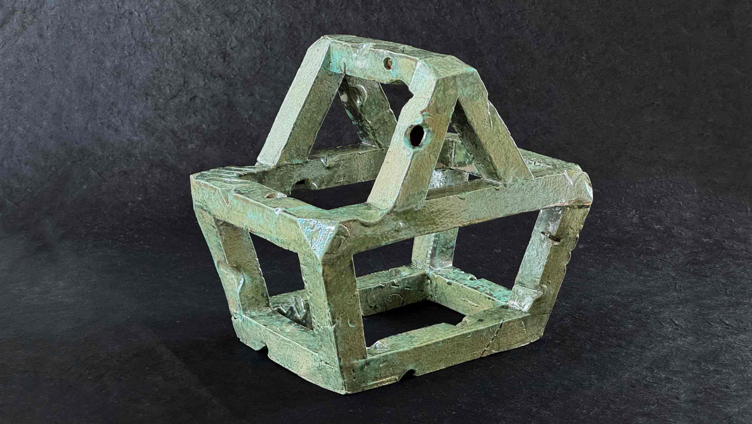 Unexpected Item - An object in the shape of a supermarket shopping basket made with extruded square section tubes of earthenware clay, fired and glazed with a reflective copper glaze